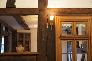 Alte sanierte Fachwerkscheune von innen mit alten braunen Holzbalken an Decken und Wänden und...