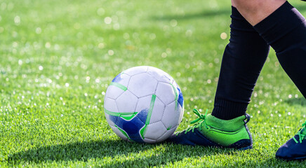 Soccer player with a ball playing on the grass of the football stadium.Close up view of football...