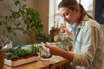Creative woman working in the workshop and looking at the phone