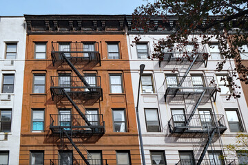 Facade of small old-fashioned apartment buildings with external fire escape - 478217794