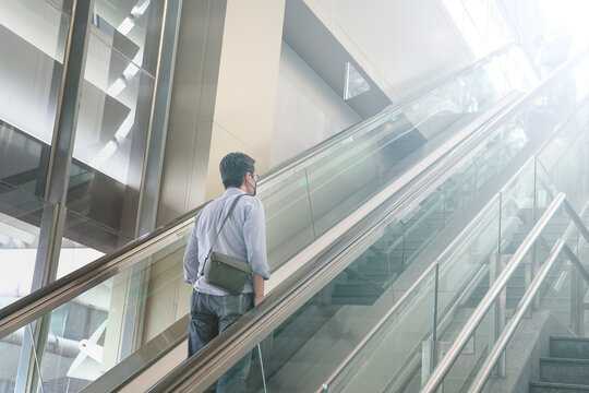 Asian man traveler with face mask on escalator inside a modern building
- Powered by Adobe