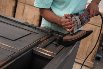 Worker polishing wood with machine