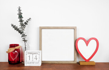Mock up wood frame with Valentines Day heart decor and calendar. Wood shelf against a white wall....