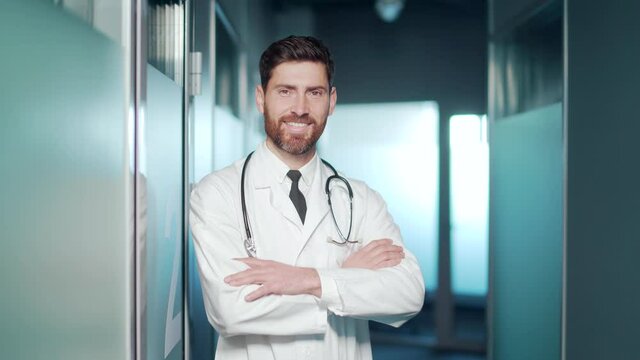 Smiling Happy Cheerful Male Doctor Medical Worker With Steethoscop Standing In Modern Hospital Clinic Looking At Camera. Headshot Portrait Senior Caucasian Man Physician Therapist With Arms Crossed