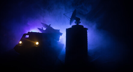 Creative artwork decoration. Silhouette of mobile air defence truck with radar antenna during...