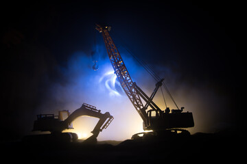 Abstract Industrial background with construction crane silhouette over amazing night sky with fog...