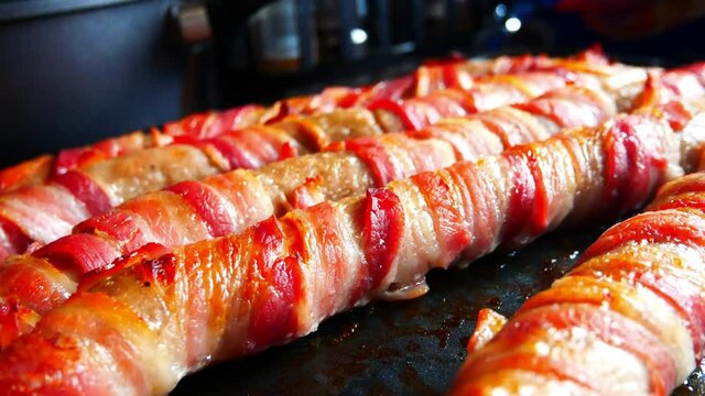 Extra large foot long pigs in blankets traditional bacon wrapped British Christmas homemade party food close up right pull back