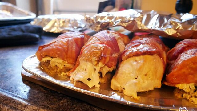 String tied turkey stuffing bacon wrapped parcels on aluminium serving tray covered in foil dolly right