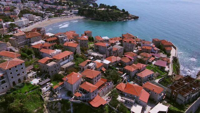 Drone with camera slowly flies over the old European resort town of Ulcinj in Montenegro and goes towards picturesque Adriatic Sea.
