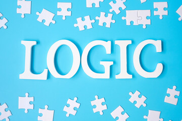 LOGIC text with white puzzle jigsaw pieces on blue background. Concepts of logical thinking,...