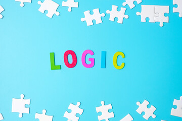 LOGIC text with white puzzle jigsaw pieces on blue background. Concepts of logical thinking, Conundrum, solutions, rational, strategy, world logic day and Education