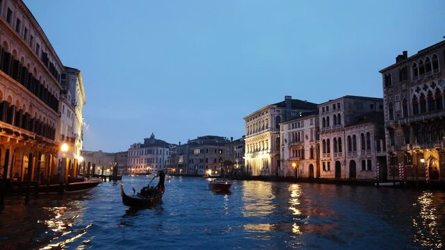 Venice, Italy - Sailing along the Grand Canal, the palaces light up at nightfall