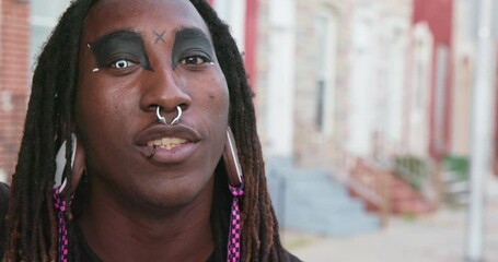 Portrait of man talking to camera with color contacts and ear ring gages