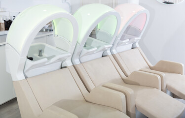 Fototapeta na wymiar Professional chairs for washing hair and massage in modern beauty salon