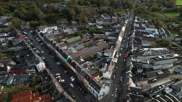 Downtown Kenmare, Republic of Ireland. Aerial View of Buildings, Street Traffic and Bay on Sunny Evening, Revealing Tilt Up Drone Shot