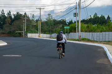 Adult man commuting by bicycle early in the morning to work as a gardener, informal employment, entrepreneur, hard-working dreamer.