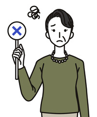 ばつのふだを持つシニア女性