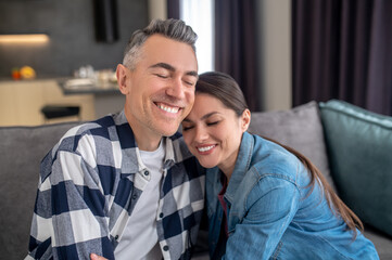 Man and woman embracing sitting on couch