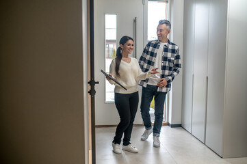 Woman with folder showing man new home