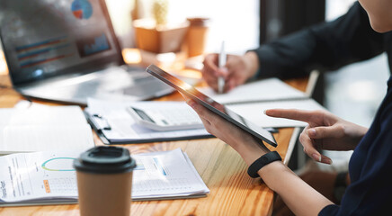 Businesspeople working at office with tablet and document on his desk, doing planning analyzing the financial report, business plan investment, finance analysis concept. Economic business discussions.