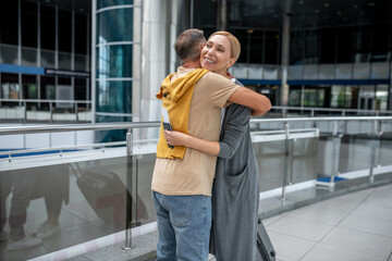 Short-haired Caucasian male embracing the airline passenger