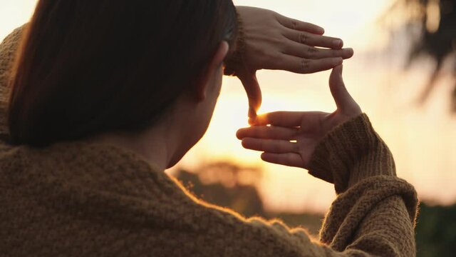 B roll - New year planning and vision concept, Close up of woman hands making frame gesture with sunset, Female capturing the sunrise.