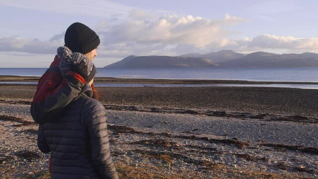 Couple in a relationship hug and look over a beautiful Scottish landscape