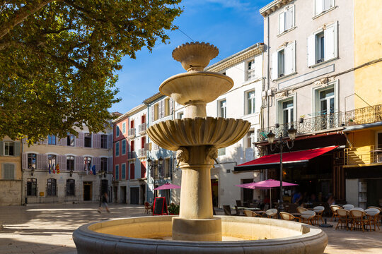 Round fountain decorated with sculptured lion heads in square of small French township
