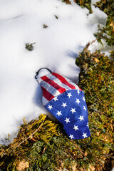 Omicron United States of America flag on abandoned mask in on snow Coronavirus Covid-19, Prevent...