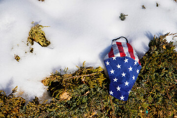 Omicron United States of America flag on abandoned mask in on snow Coronavirus Covid-19, Prevent...