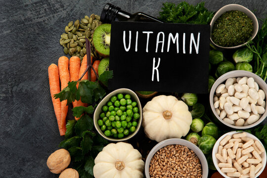Foods high in vitamin K on dark background.