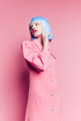 fashionable woman in blue wig pink dress red lips isolated background