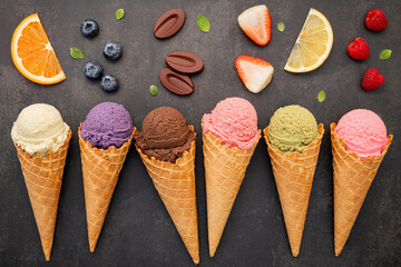 Flat lay ice cream cones collection on dark stone background . Blank crispy ice cream cone with...