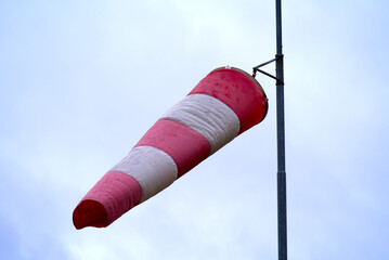 Close-up of red and white striped windsock at the airport on a sunny winter day. Photo taken...