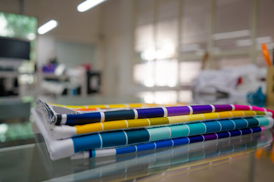 A blurred background photo of the inside of printing room. Color Palette Guide. Sample Colors Catalog. Multicolored bright background. RGB. CMYK. Printing sublimation house. Selective focus.