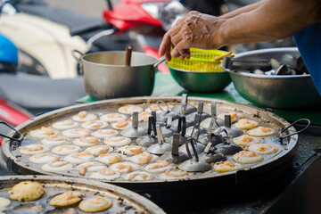 Sizzling Vietnamese mini shrimp pancake and onion- Vietnamese cuisine, Banh Khot. Vendor hawker...