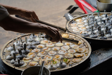 Sizzling Vietnamese mini shrimp pancake and onion- Vietnamese cuisine, Banh Khot. Vendor hawker...
