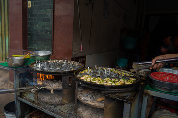 Sizzling Vietnamese mini shrimp pancake and onion- Vietnamese cuisine, Banh Khot. Vendor hawker...