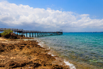 Obraz premium Wooden pier leading to clear blue ocean on Prison island, Zanzibar, Tanzania