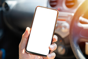 A young man drives with a phone in his hand,
