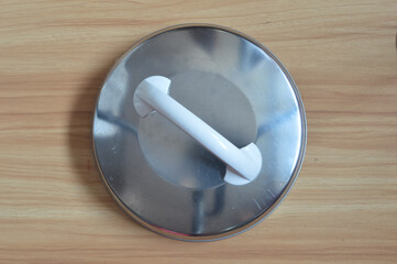 Rice cooker steel cover isolated on a wooden background