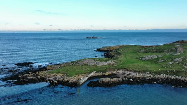 Muglins Lighthouse, Dublin, Ireland. December 2021 Drone gradually pushes across Dalkey Island towards the Lighthouse from the west with Dublin Bay and the Irish Sea in the distance.