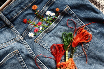 Creative DIY project, hand embroidery at home on jeans, creative hobby, clothes recycle, floral...