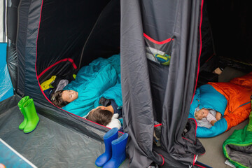 Child, sleeping in sleeping bag in a tent