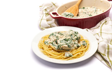 Portion of delicious meatballs with spinach in a creamy sauce and pasta