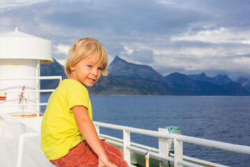 Fototapeta na wymiar Child, cute boy, looking at the mountains from a ferry in Nortern Norway