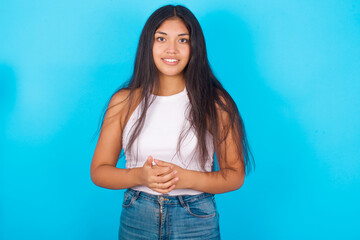 Fototapeta na wymiar Business Concept - Portrait of Young hispanic girl wearing tank top over blue background holding hands with confident face.