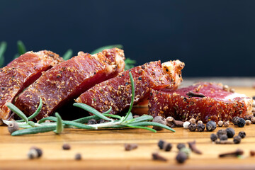 dried and spiced meat sliced on a wooden board