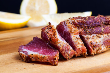 dried and spiced meat sliced on a wooden board
