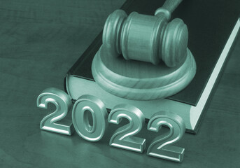 Wooden judge gavel on legal book and numbers 2022.	